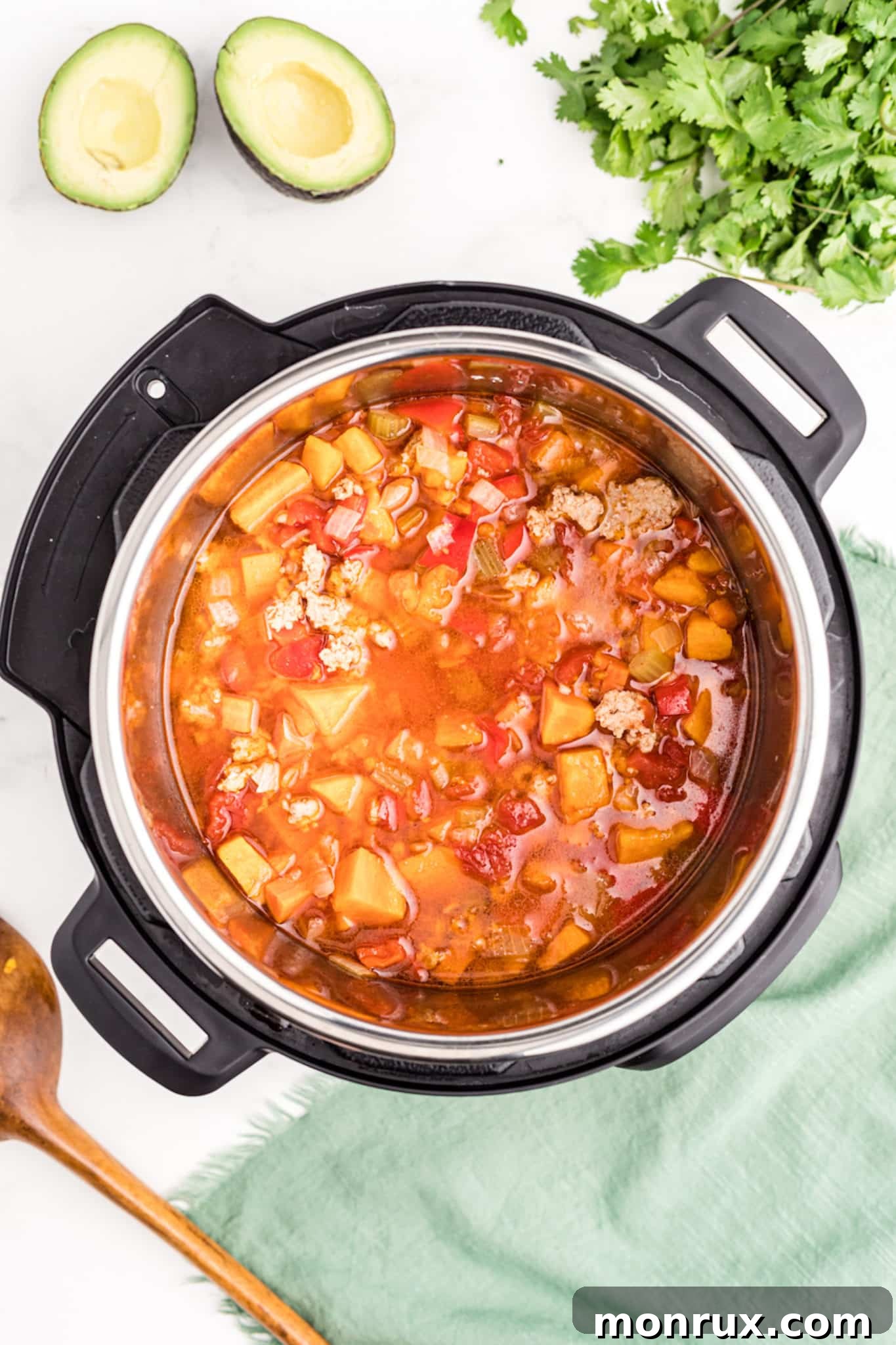 A close-up shot of rich, cooked turkey and vegetable chili simmering inside an Instant Pot, highlighting its hearty texture and vibrant ingredients.