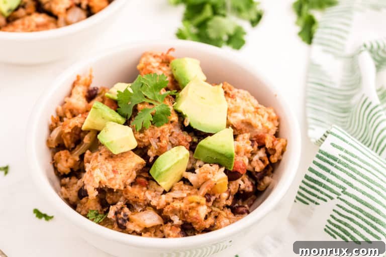 A bowl of chicken and rice with avocado.