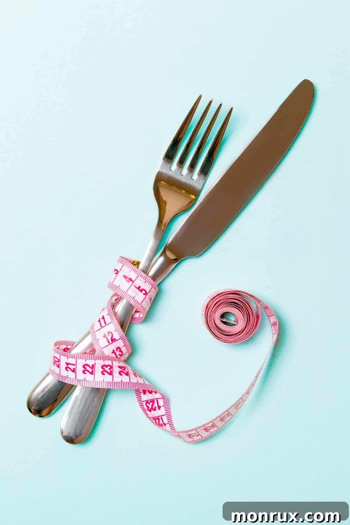 A fork and knife elegantly wrapped with a measuring tape, symbolizing mindful eating and healthy weight management for women.