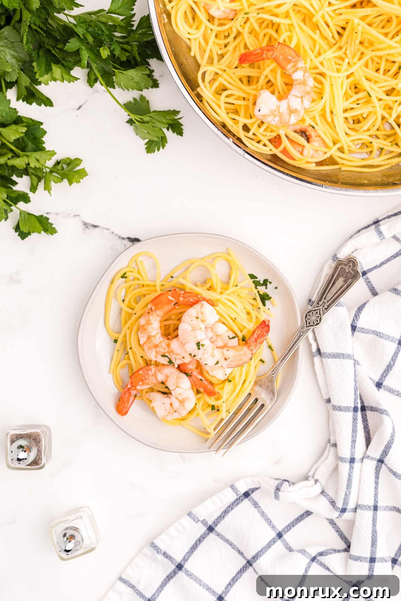 A beautifully plated individual serving of Gluten-Free Dairy-Free Shrimp Scampi, elegantly garnished with a sprinkle of fresh parsley, presented on a light-colored plate.