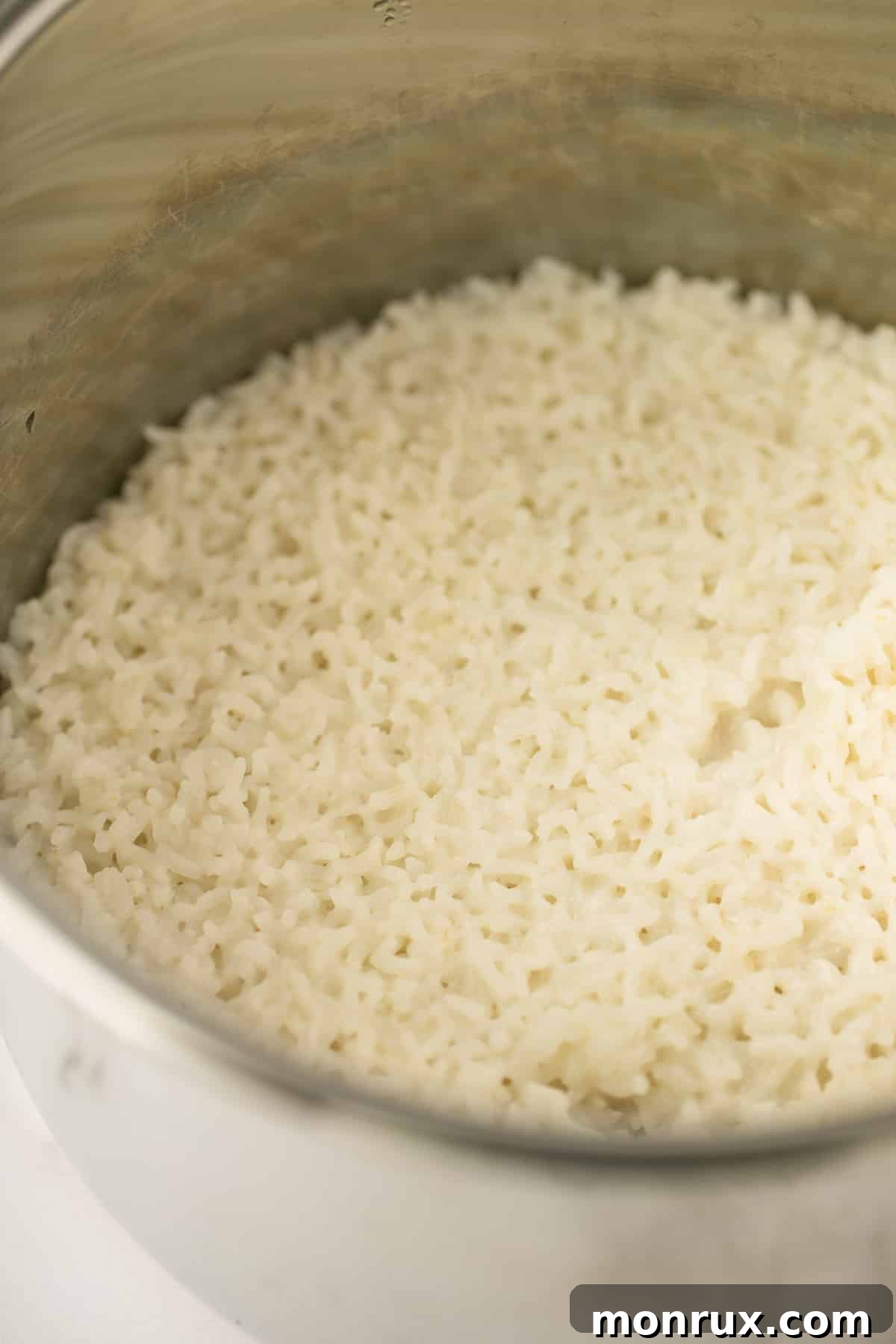 Fluffy, cooked coconut rice inside the Instant Pot, with steam gently rising, after the lid has been removed.