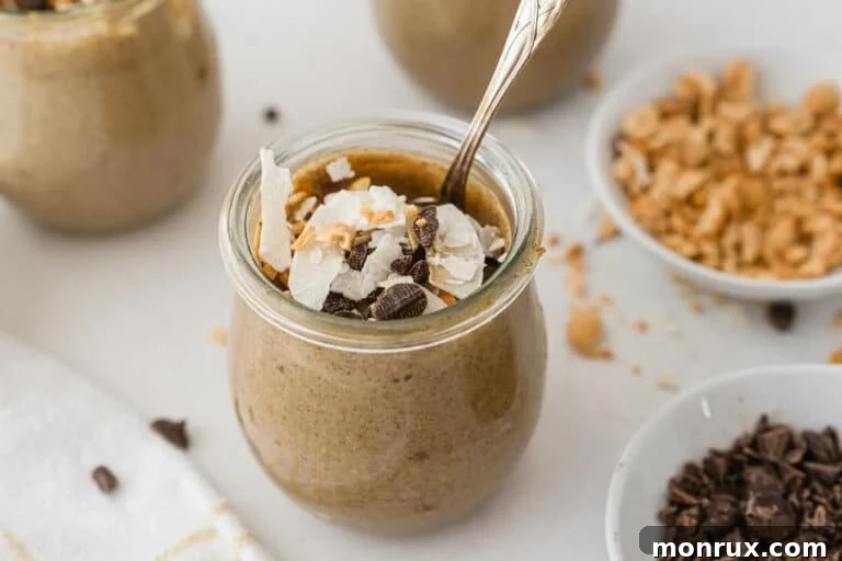 Small jars of peanut butter chia pudding, beautifully layered and topped with chocolate and coconut flakes, showcasing its delicious appeal.