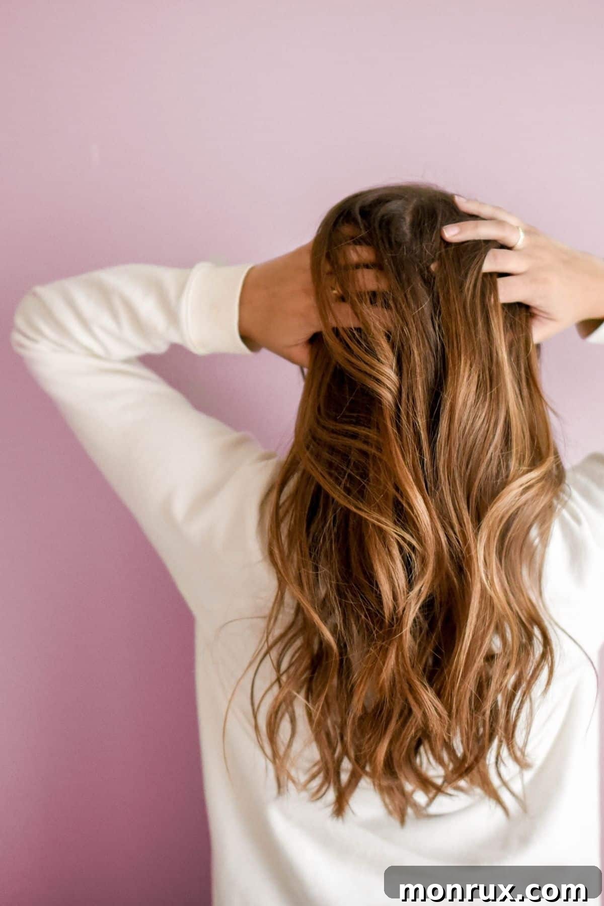 A woman with long brown hair gently holds her head in a gesture of contemplation or mild discomfort, reflecting the mental and emotional toll of chronic illness.
