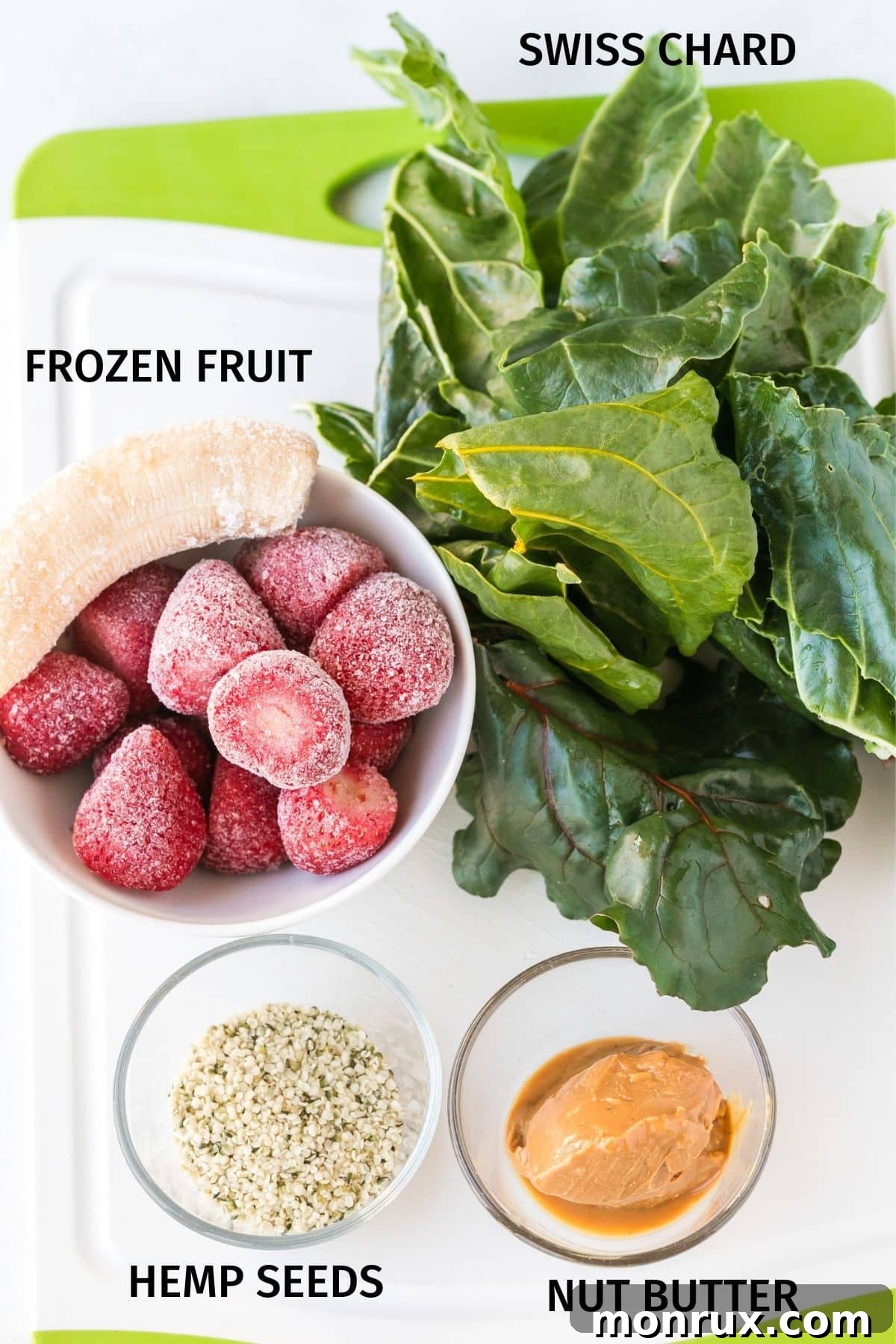 Labeled ingredients for a Swiss chard smoothie, including frozen fruit, Swiss chard, hemp seeds, and nut butter, arranged for blending.
