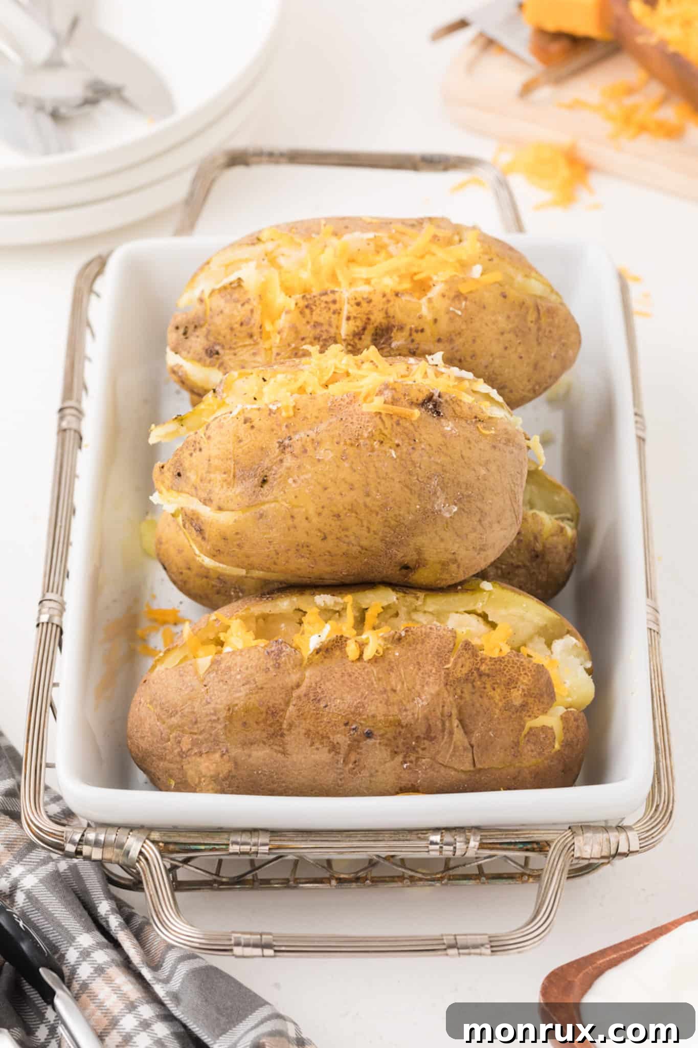 Golden-brown Instant Pot baked potatoes artfully arranged on a rustic serving platter.