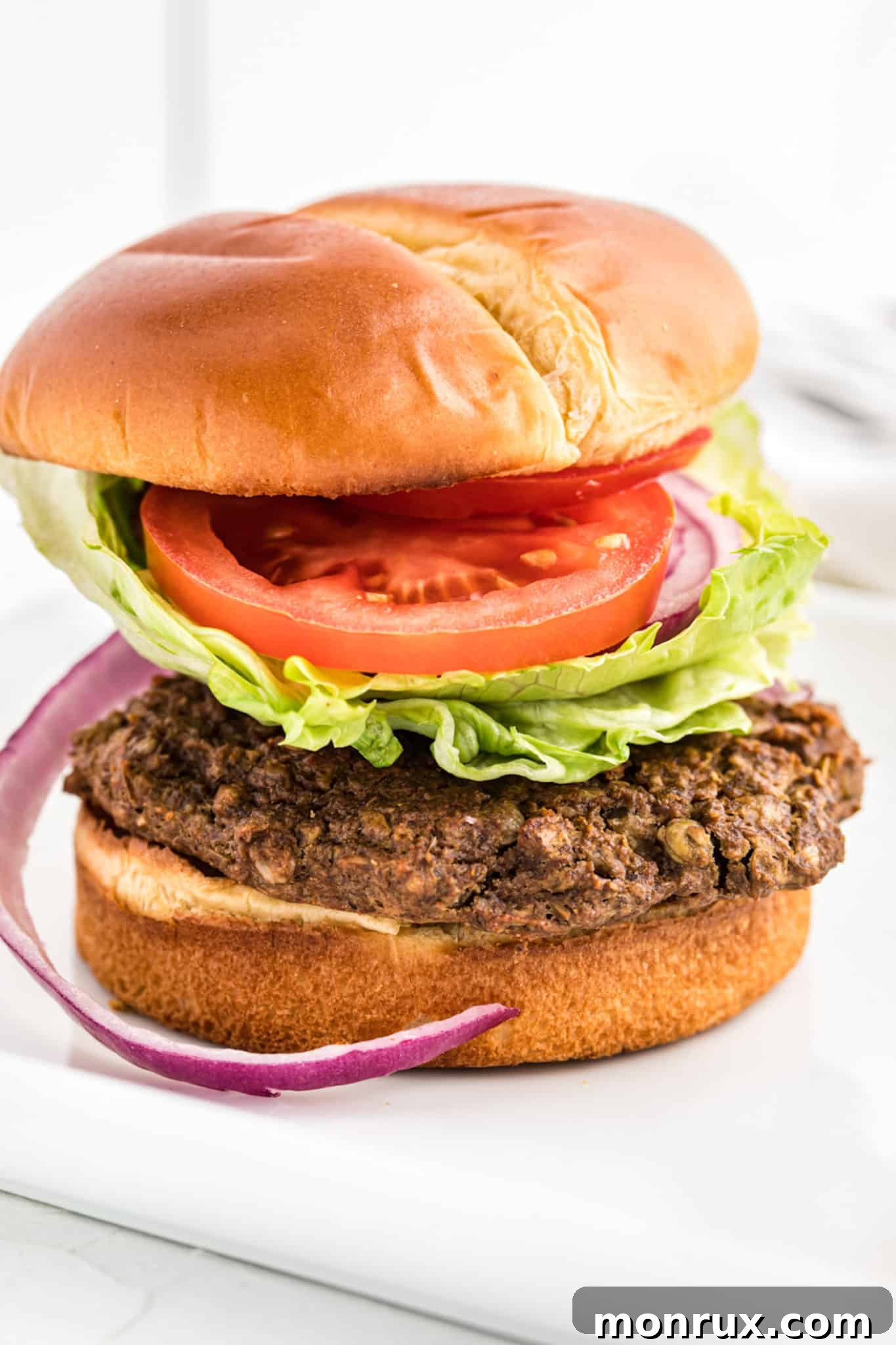 A delicious gluten-free lentil burger served on a toasted bun with fresh lettuce and tomato.