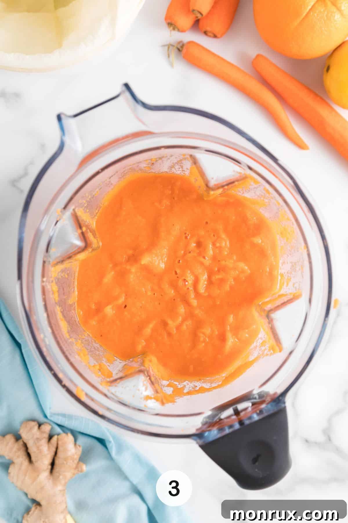 Third step of making carrot juice: a blender actively blending the ingredients to a smooth consistency.