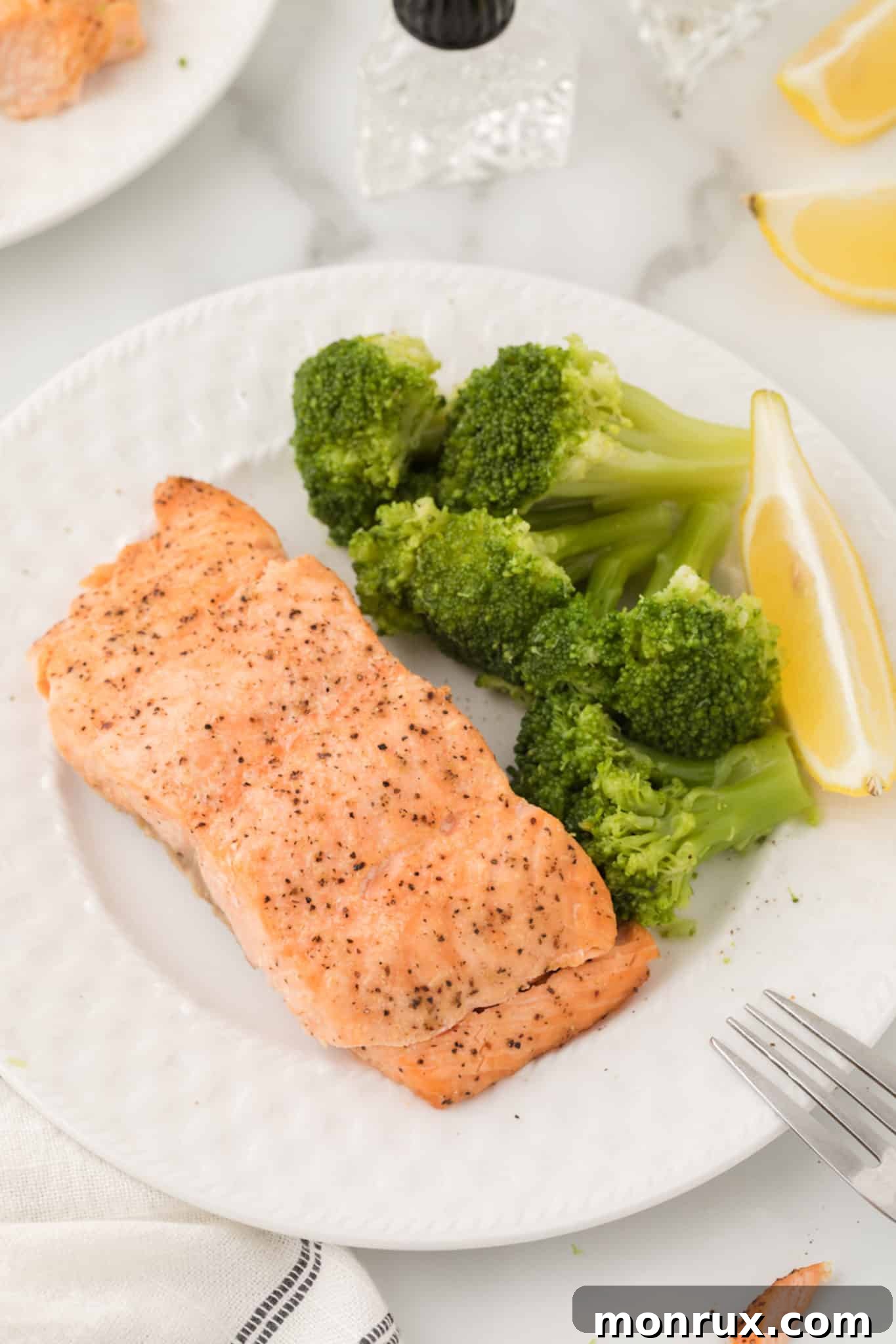 air fryer Salmon served with broccoli and lemon.