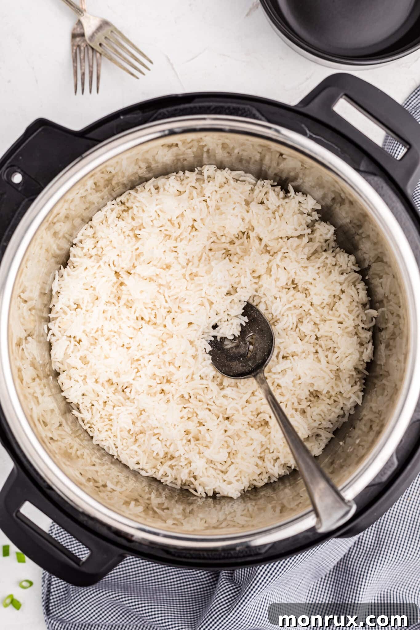 Fluffy white Basmati rice in the Instant Pot, ready to be served with a large spoon.