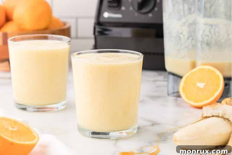 Two glasses of orange banana smoothie, ready to be enjoyed.