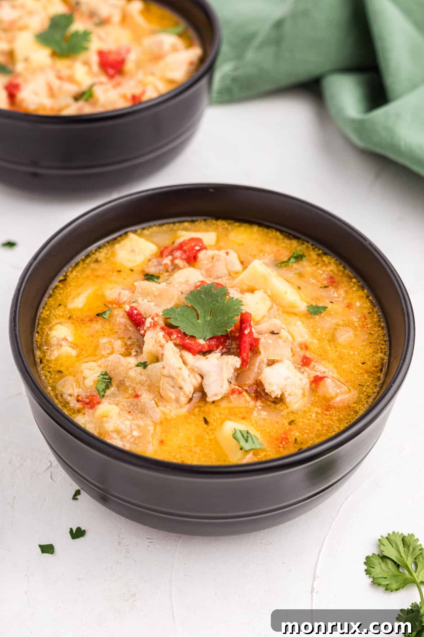 two bowls of cooked sweet potato chicken curry.