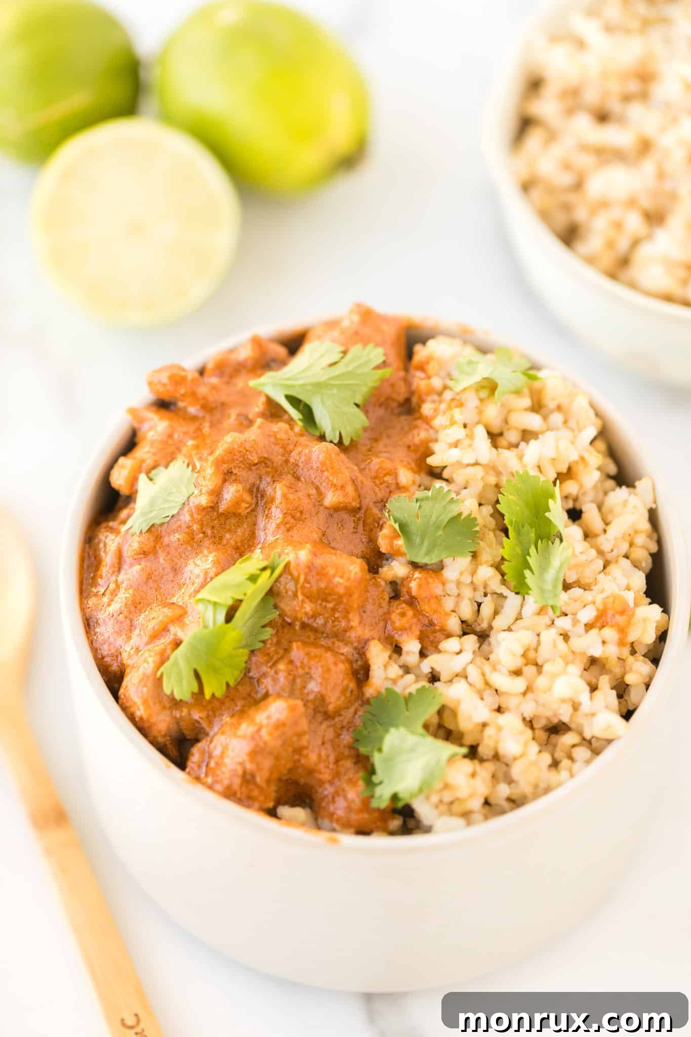 Instant Pot peanut chicken served with brown rice in a bowl, garnished with fresh cilantro.