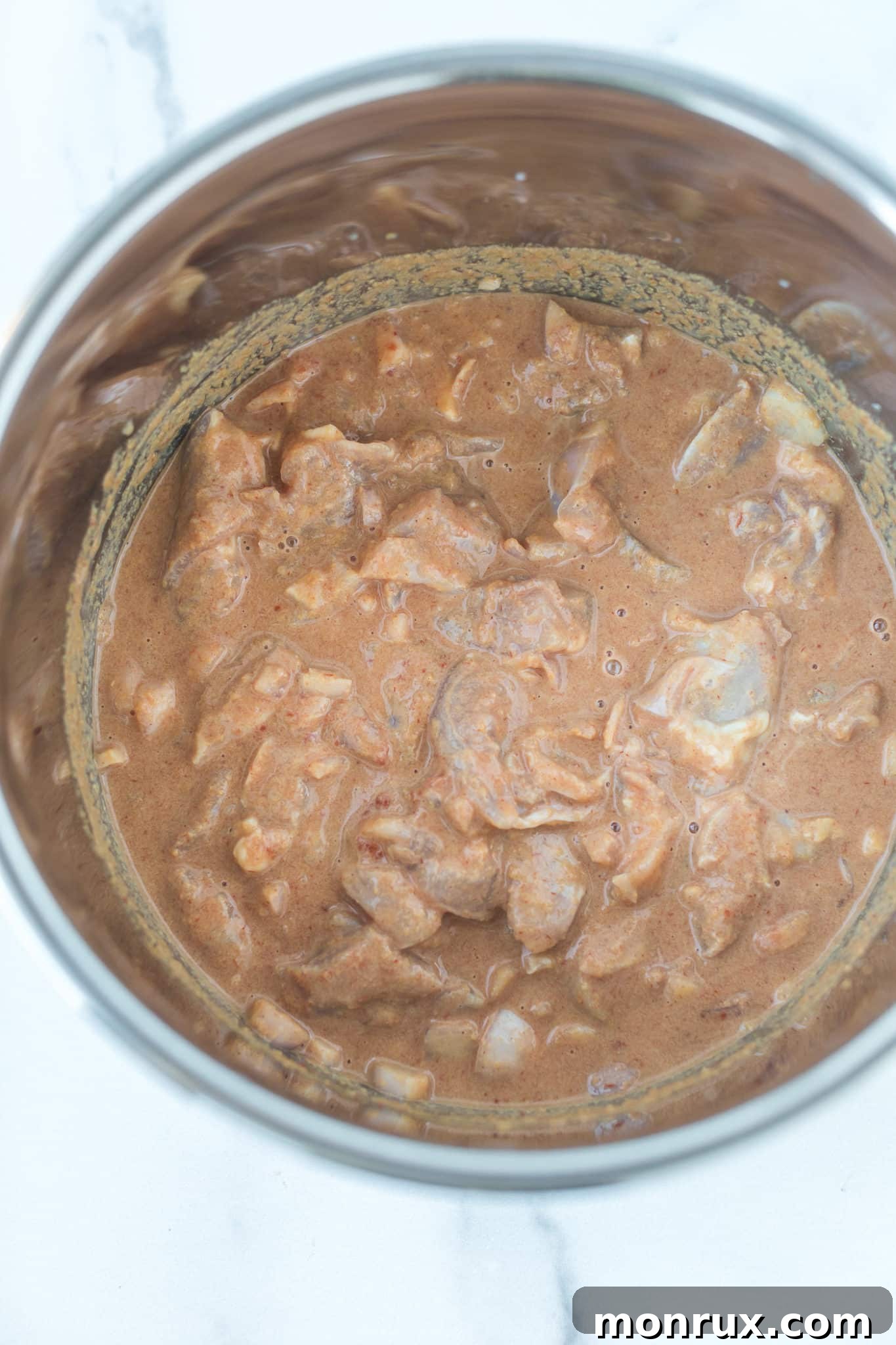 All the ingredients for Instant Pot peanut chicken mixed together in the inner pot of an Instant Pot.