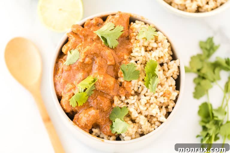 Peanut chicken served in a white bowl with a wooden spoon