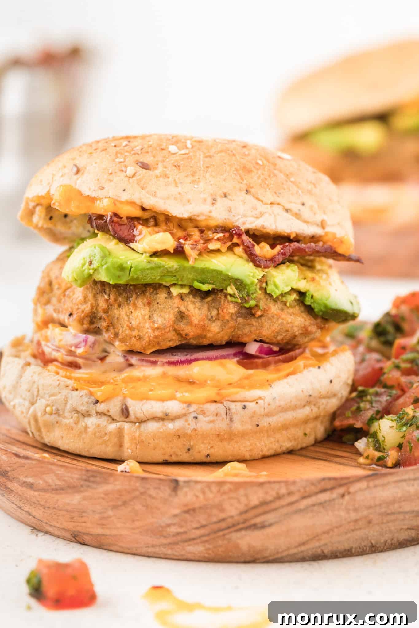A perfectly cooked air fryer turkey burger served on a toasted bun with fresh onion, ripe avocado, and a dollop of zesty sauce, highlighting its juicy interior.