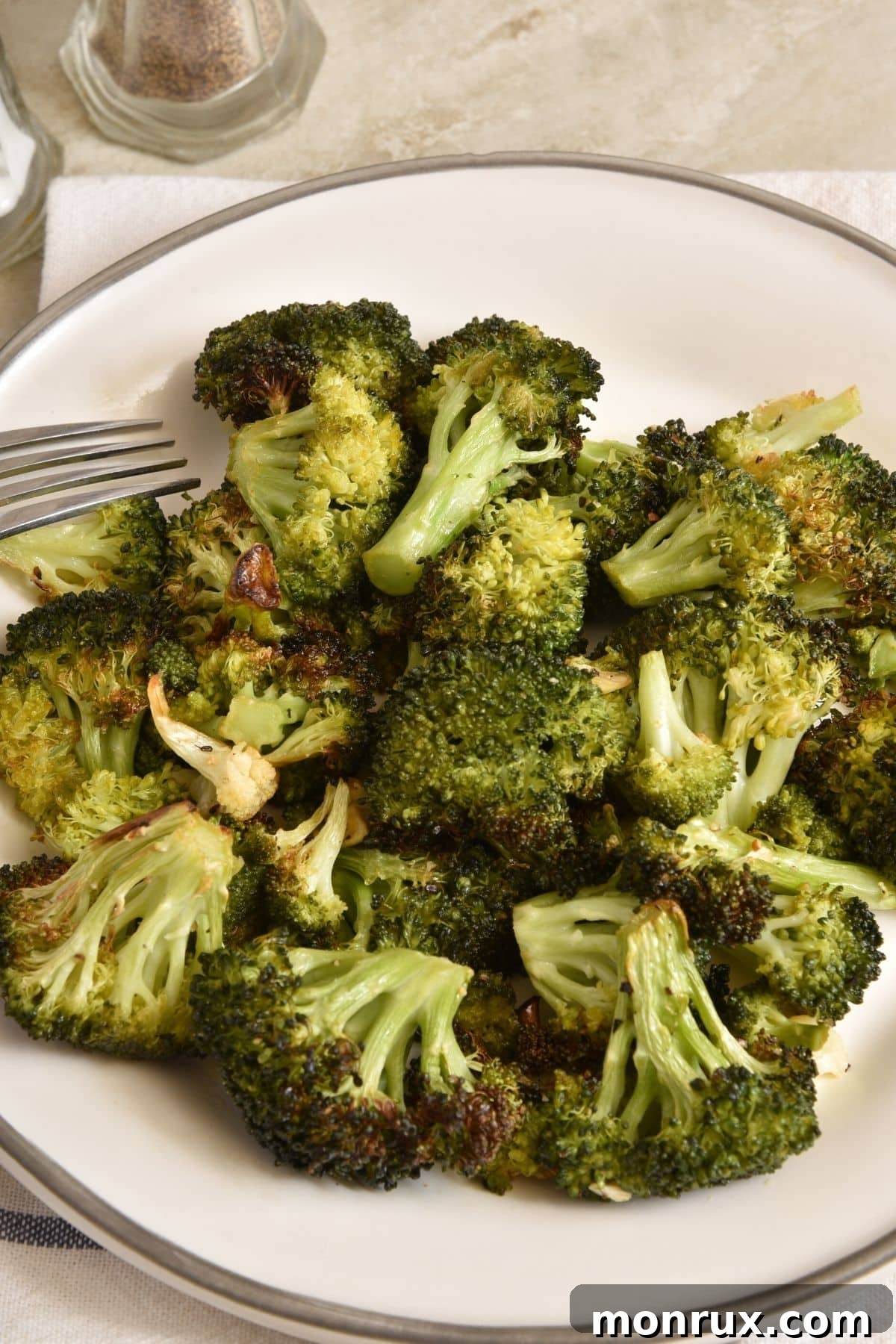 Perfectly roasted crispy broccoli in a white bowl, ready to serve.