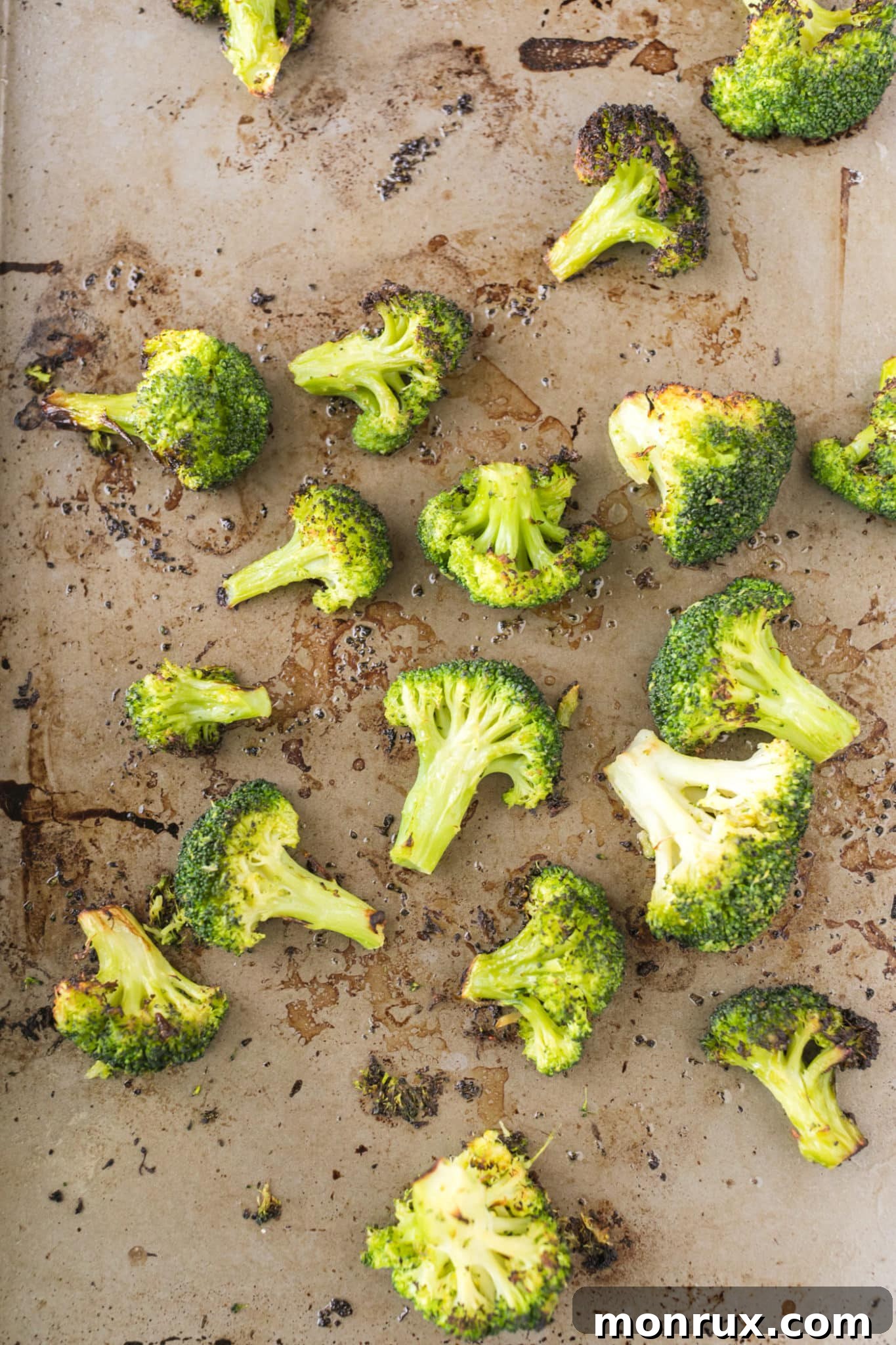 Beautifully roasted broccoli florets with crispy, browned edges on a baking sheet.