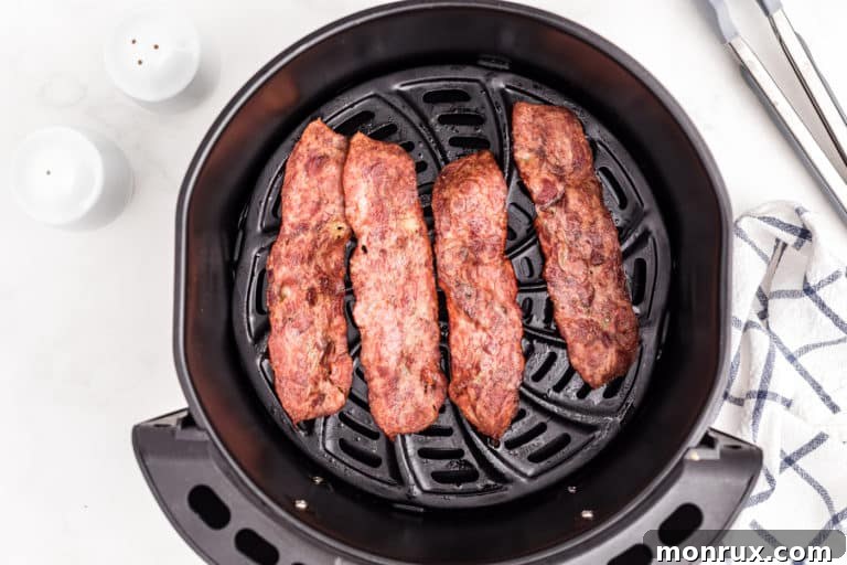 Air fryer turkey bacon slices ready in the basket.