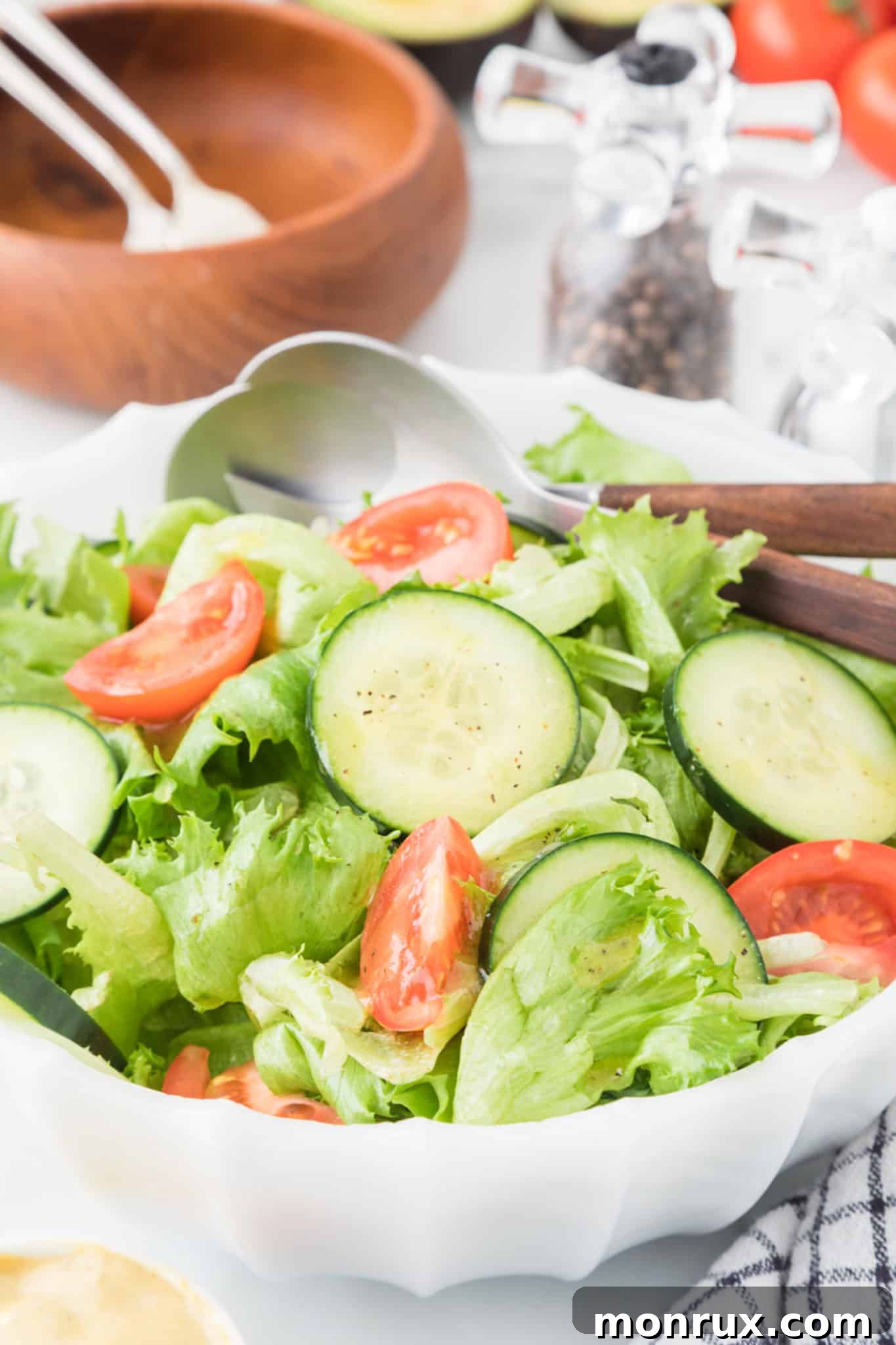 A delicious green salad with fresh tomatoes and cucumbers, beautifully dressed with a homemade honey mustard vinaigrette.
