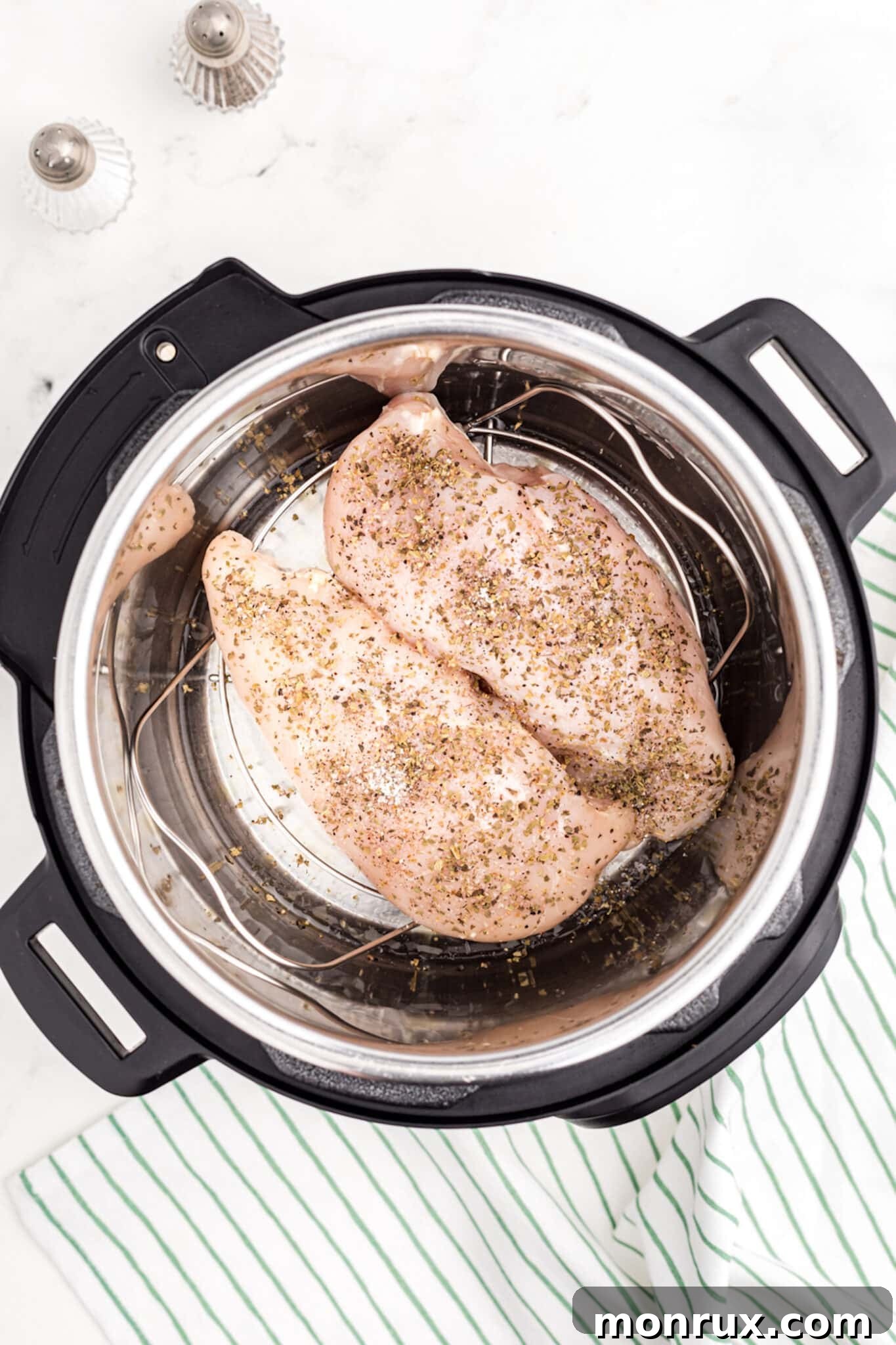Seasoned turkey tenderloins placed on a trivet inside an Instant Pot, ready for cooking.