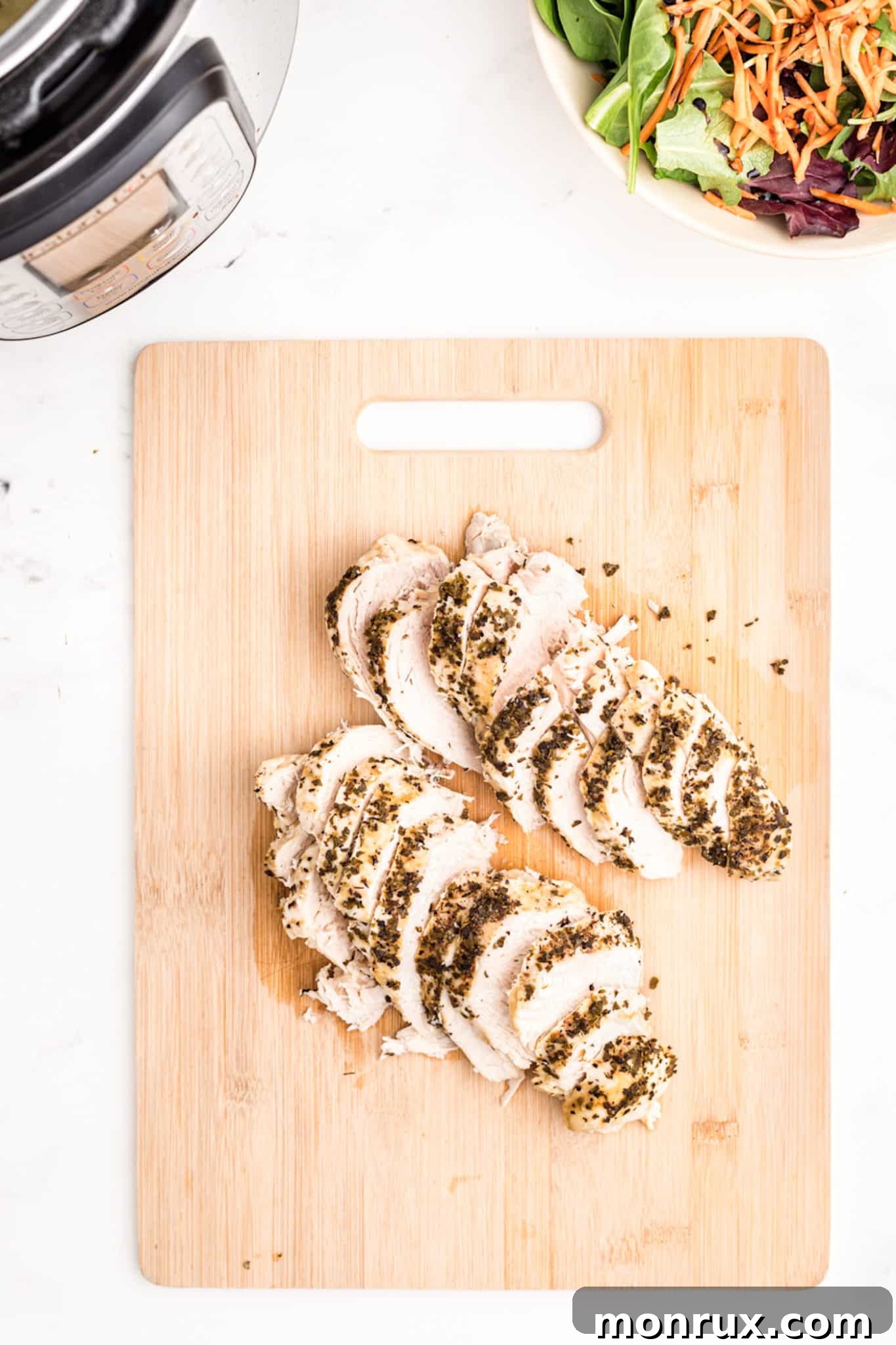 Expertly sliced turkey tenderloin arranged on a rustic wooden cutting board, showcasing its tender texture.