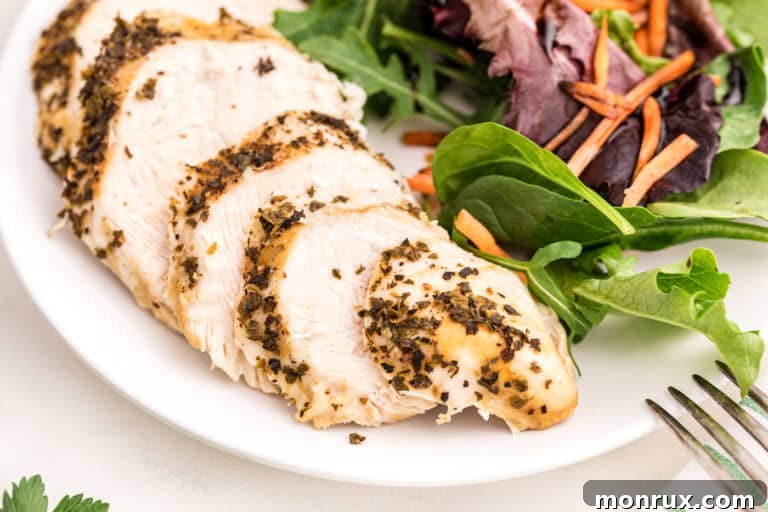Beautifully sliced Instant Pot turkey tenderloin on a plate, garnished with a fresh green salad, ready to be served.