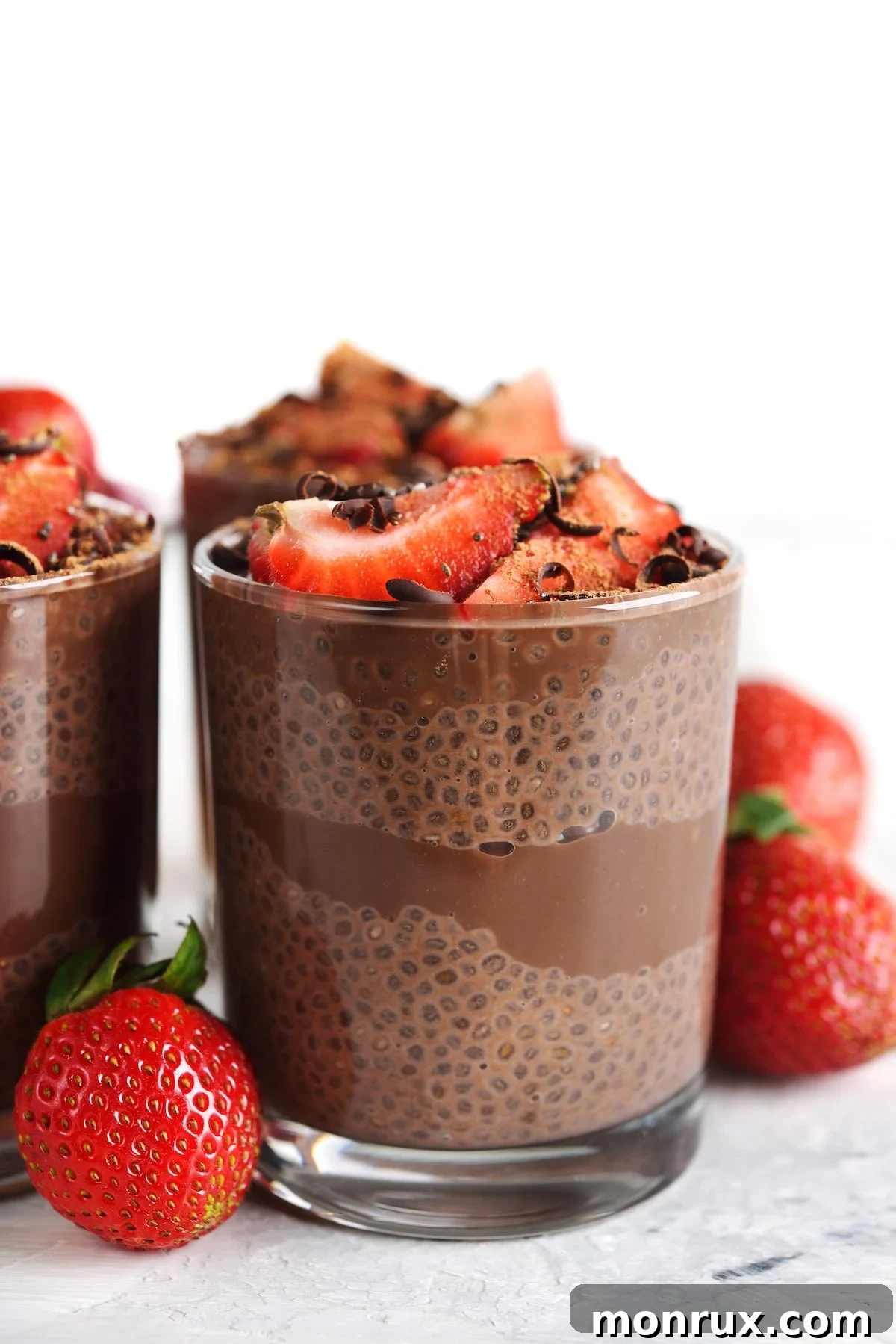 Rich chocolate chia pudding layered with fresh strawberries in a glass jar, ready to be enjoyed.