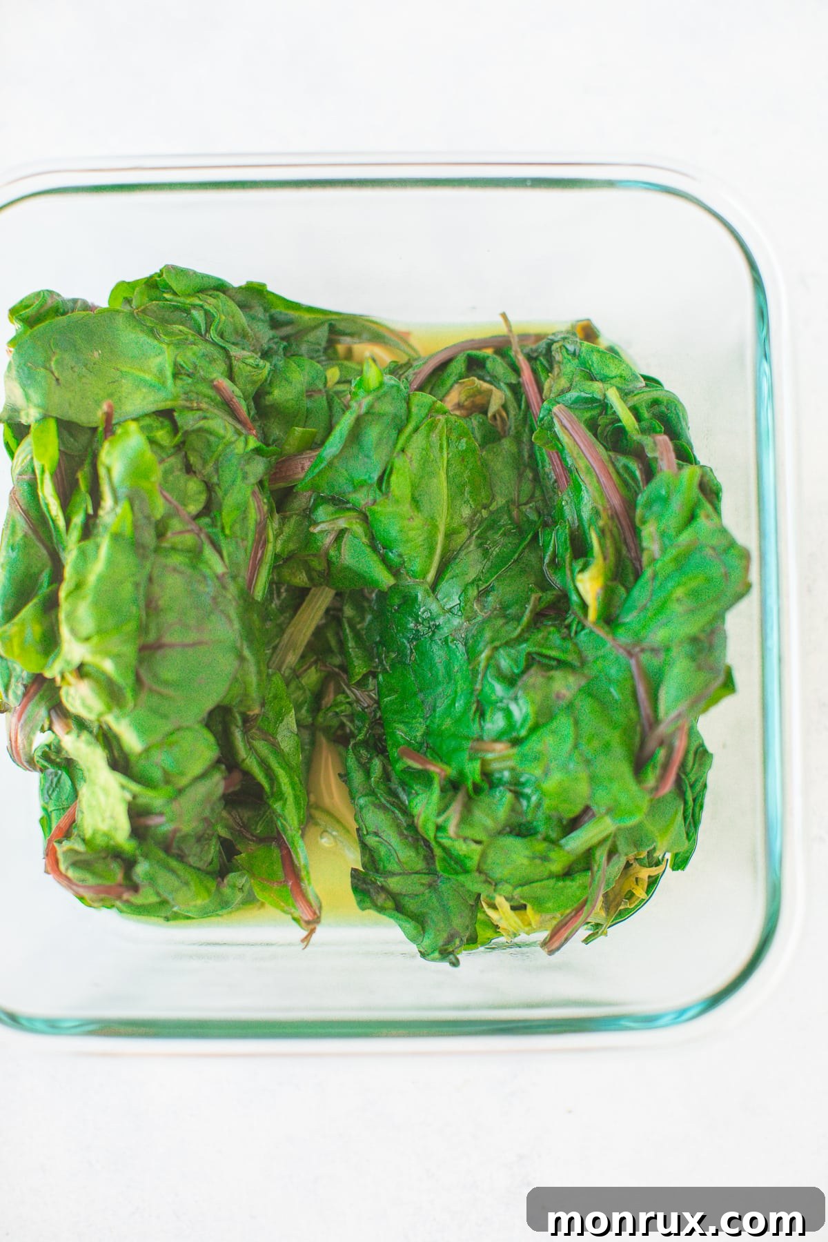 Steamed greens in a glass container, cooling down