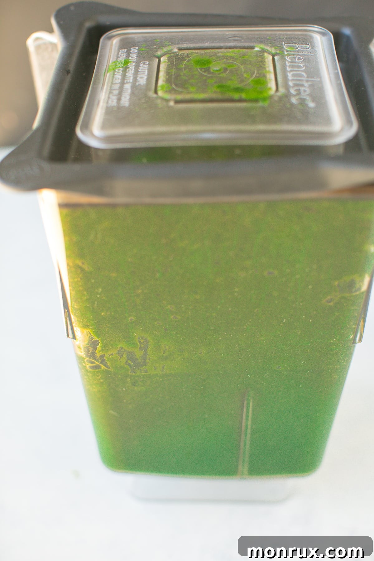 Pureed greens in the base of a high-speed blender, ready for freezing