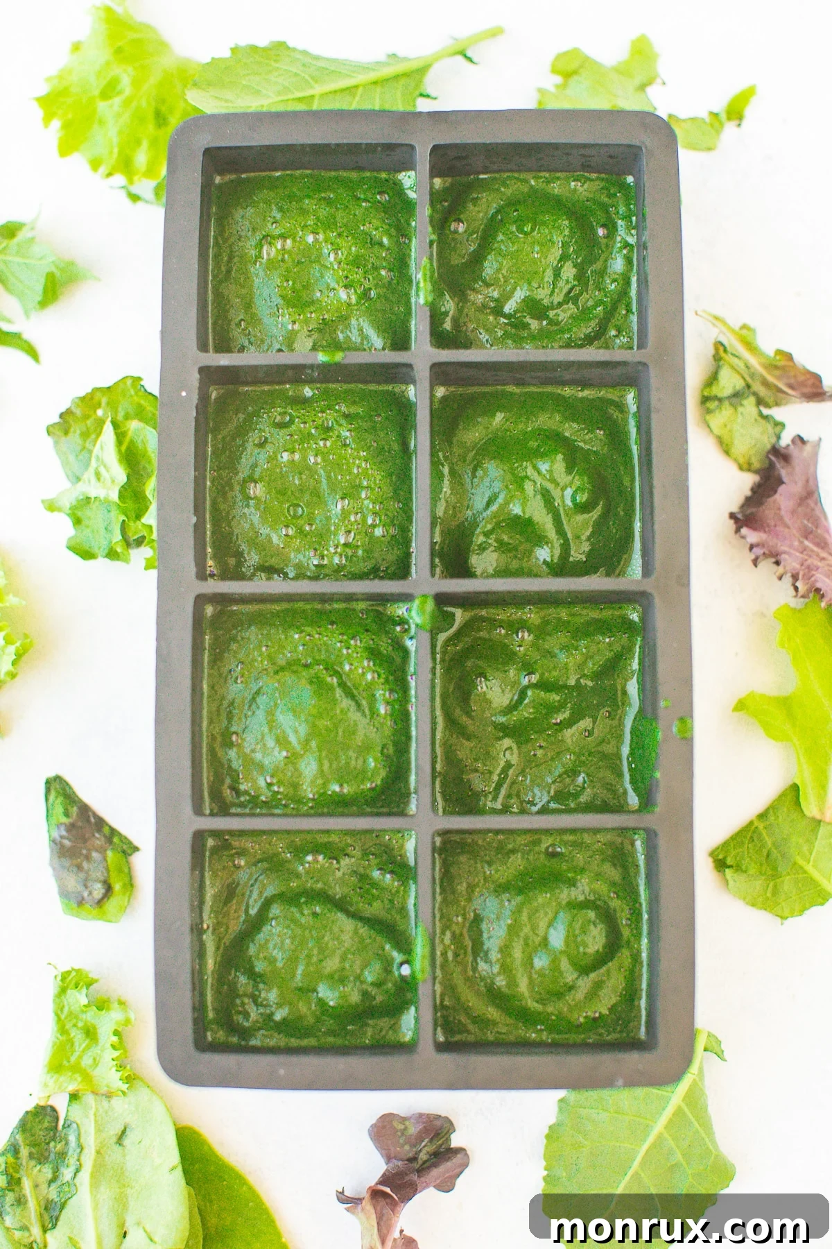 Pureed spinach in an ice cube tray, ready to be placed in the freezer