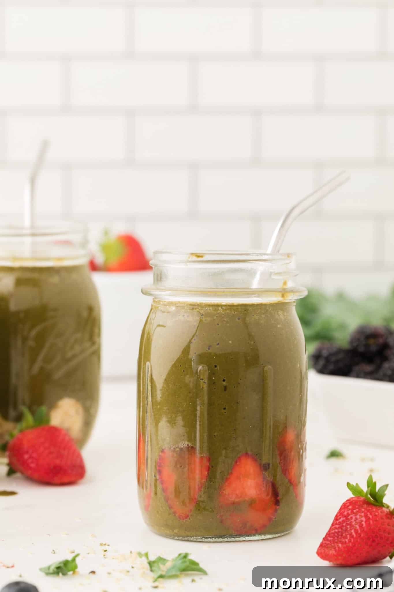 Two jars of Kale Berry Smoothie on a table, showcasing a delicious use for frozen greens