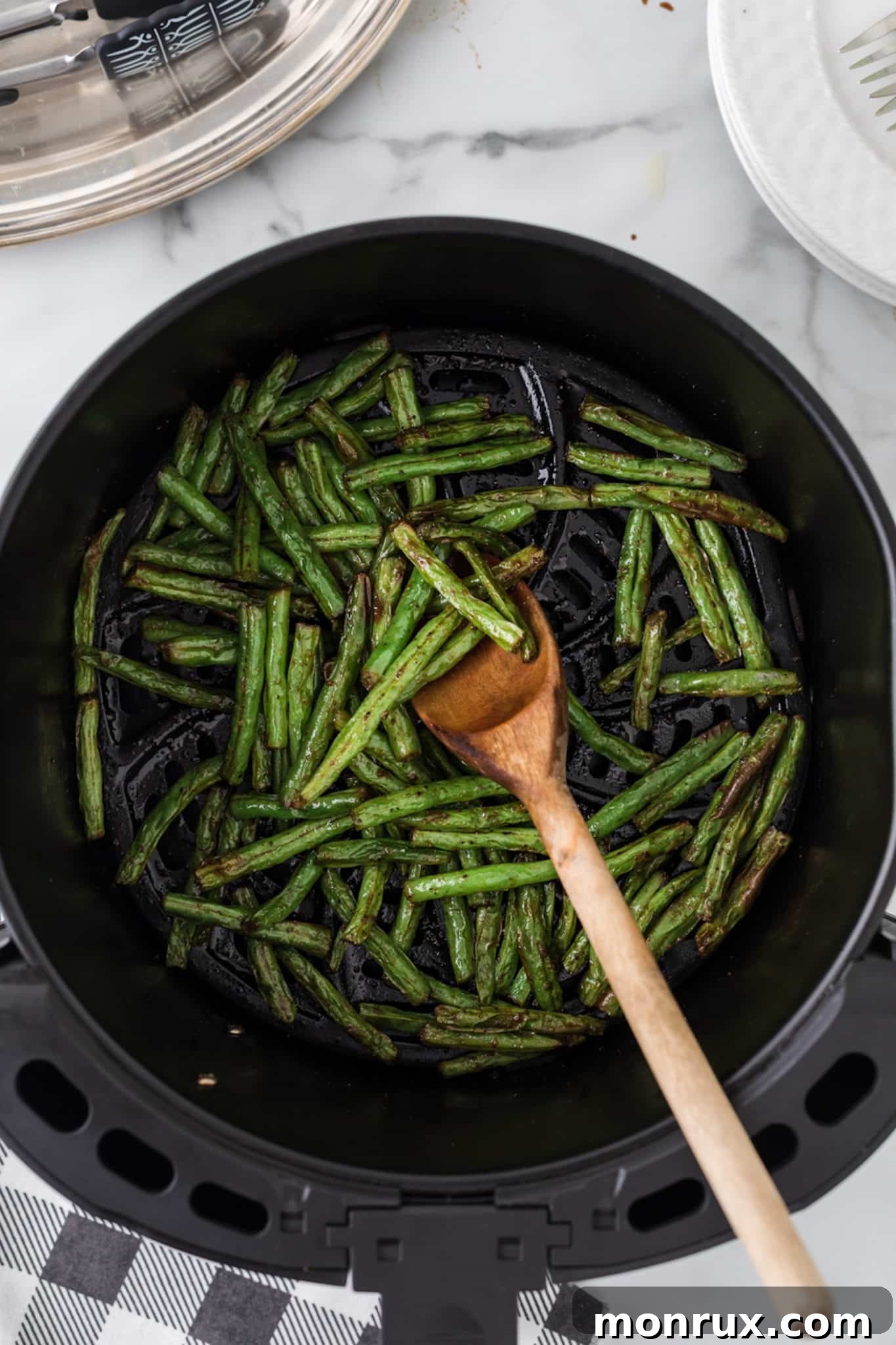 cooked green beans in air fryer basket.