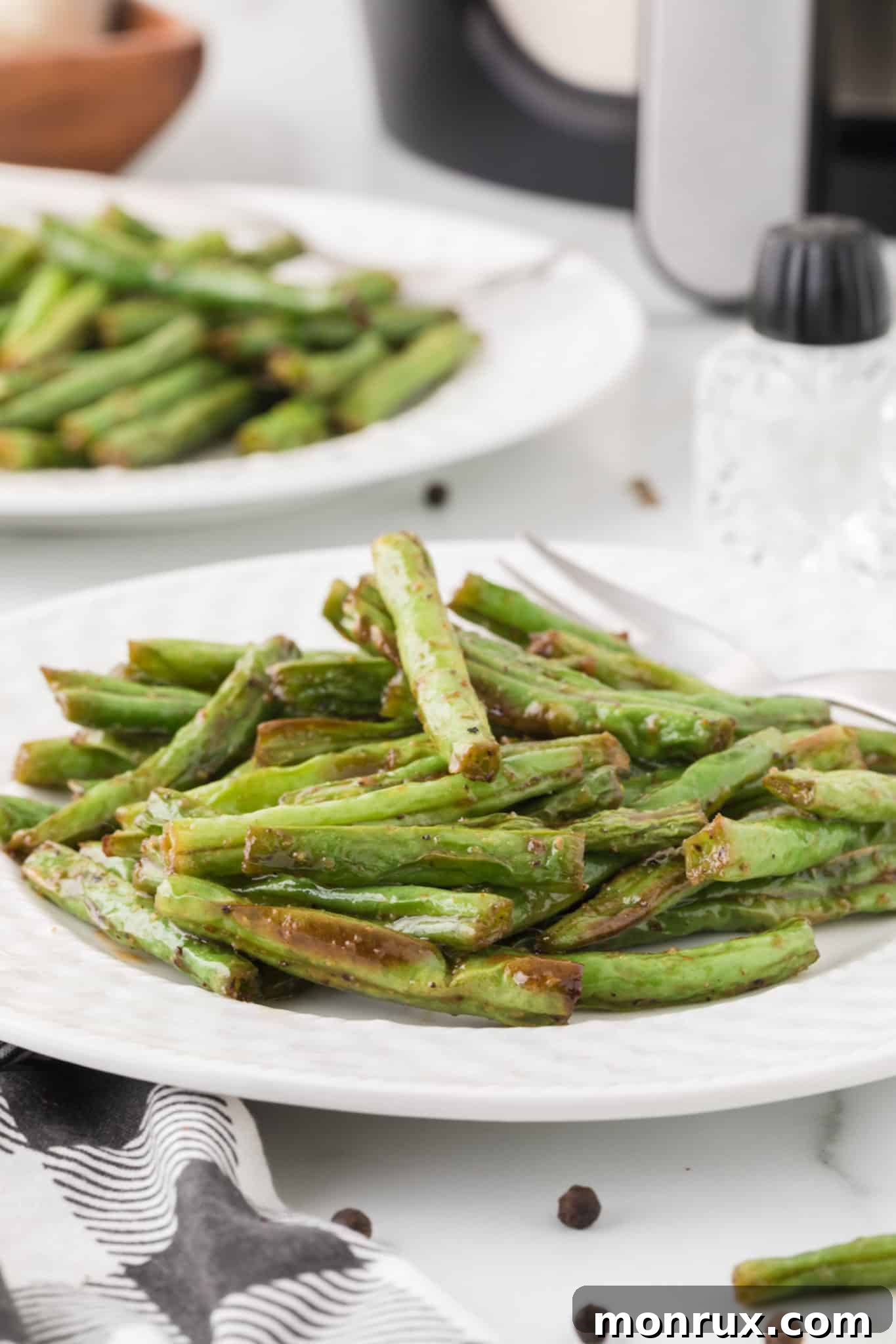 two plates of cooked air fryer green beans.