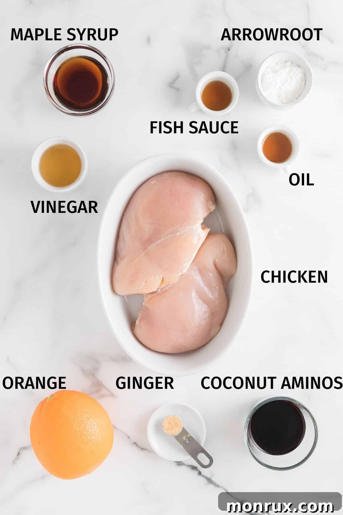 Ingredients for Air Fryer Orange Chicken in small bowls on a white surface.
