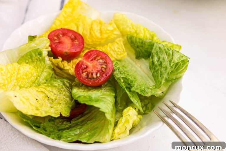 romaine salad on a white plate with a fork