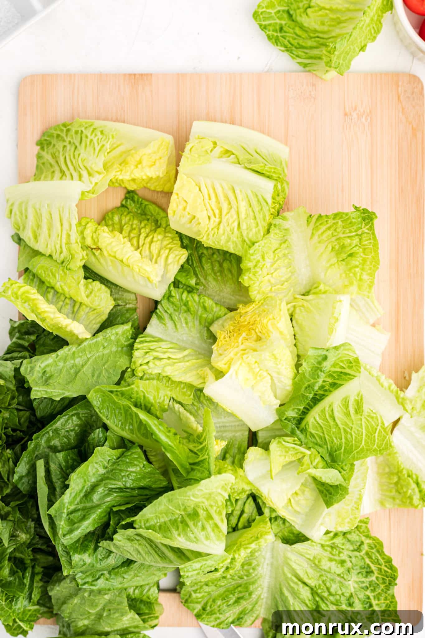 Freshly chopped romaine lettuce arranged neatly on a cutting board, ready for a salad.