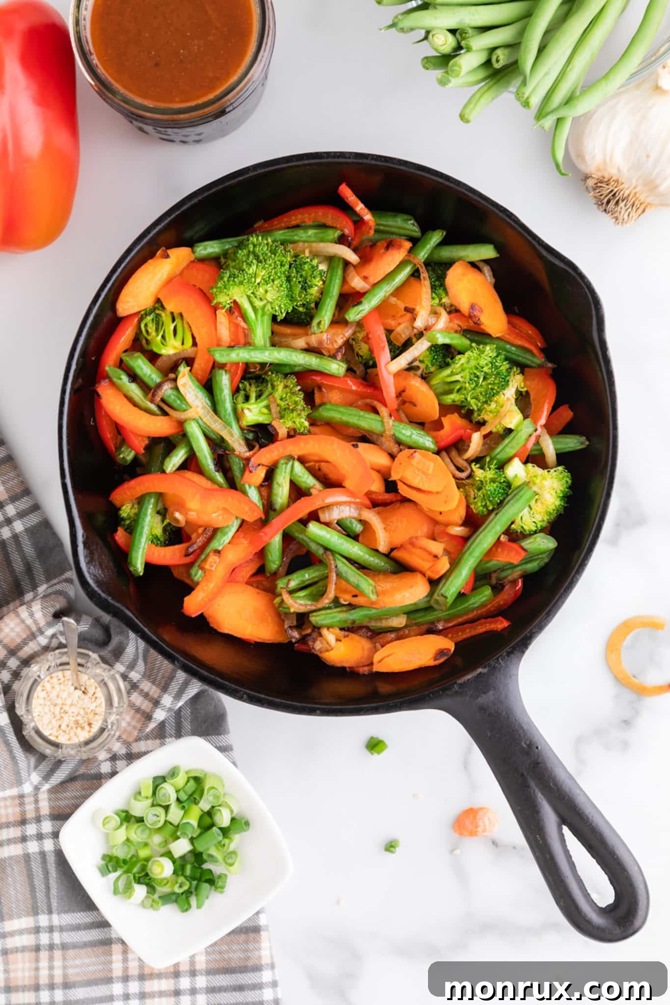 A skillet filled with colorful veggies, ready for the gluten-free stir-fry sauce to be added and mixed.