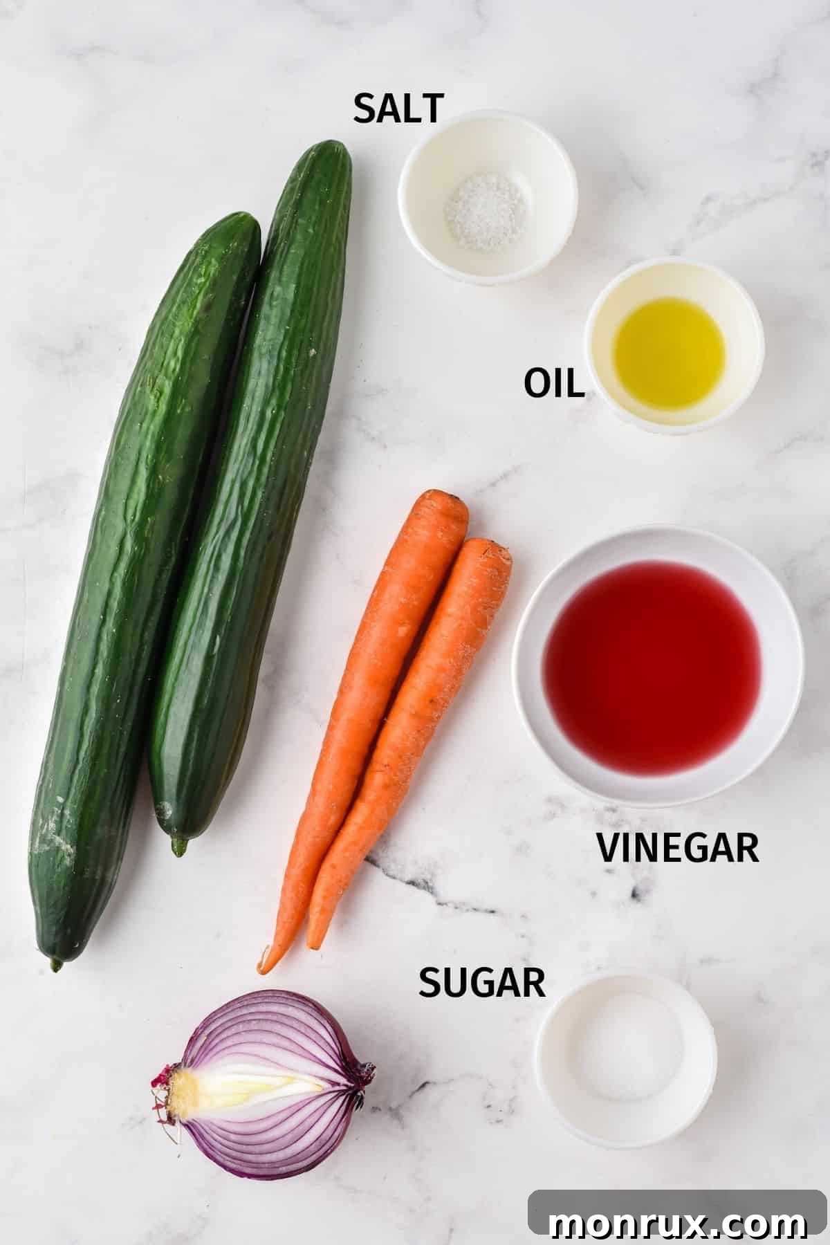A selection of fresh ingredients for cucumber carrot salad, arranged neatly in small bowls on a clean white surface.