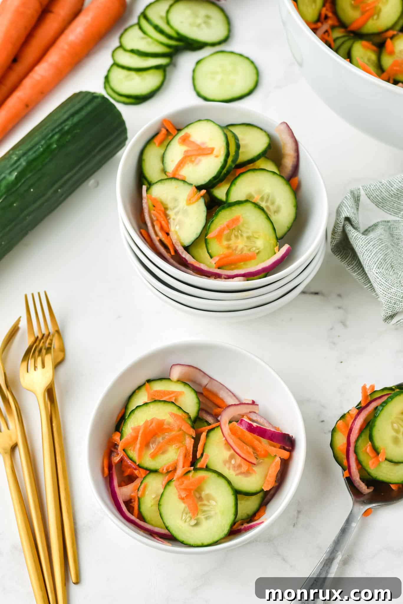 Several small white bowls, each holding a perfectly portioned serving of the delicious carrot cucumber salad.