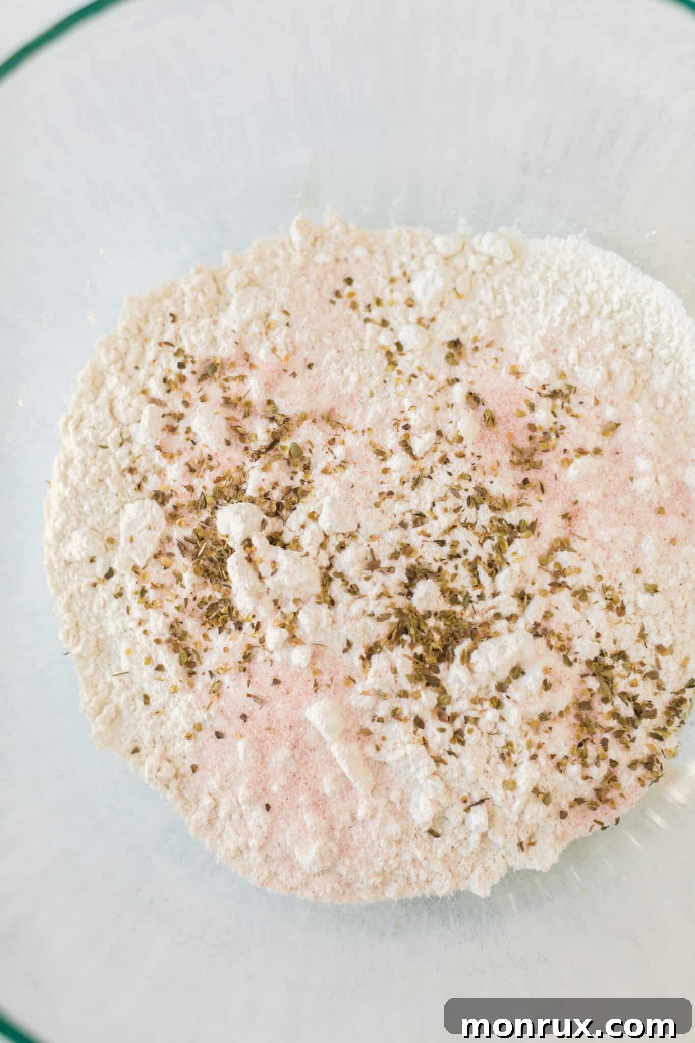 Cassava flour being mixed with other dry ingredients in a bowl to make pizza dough.