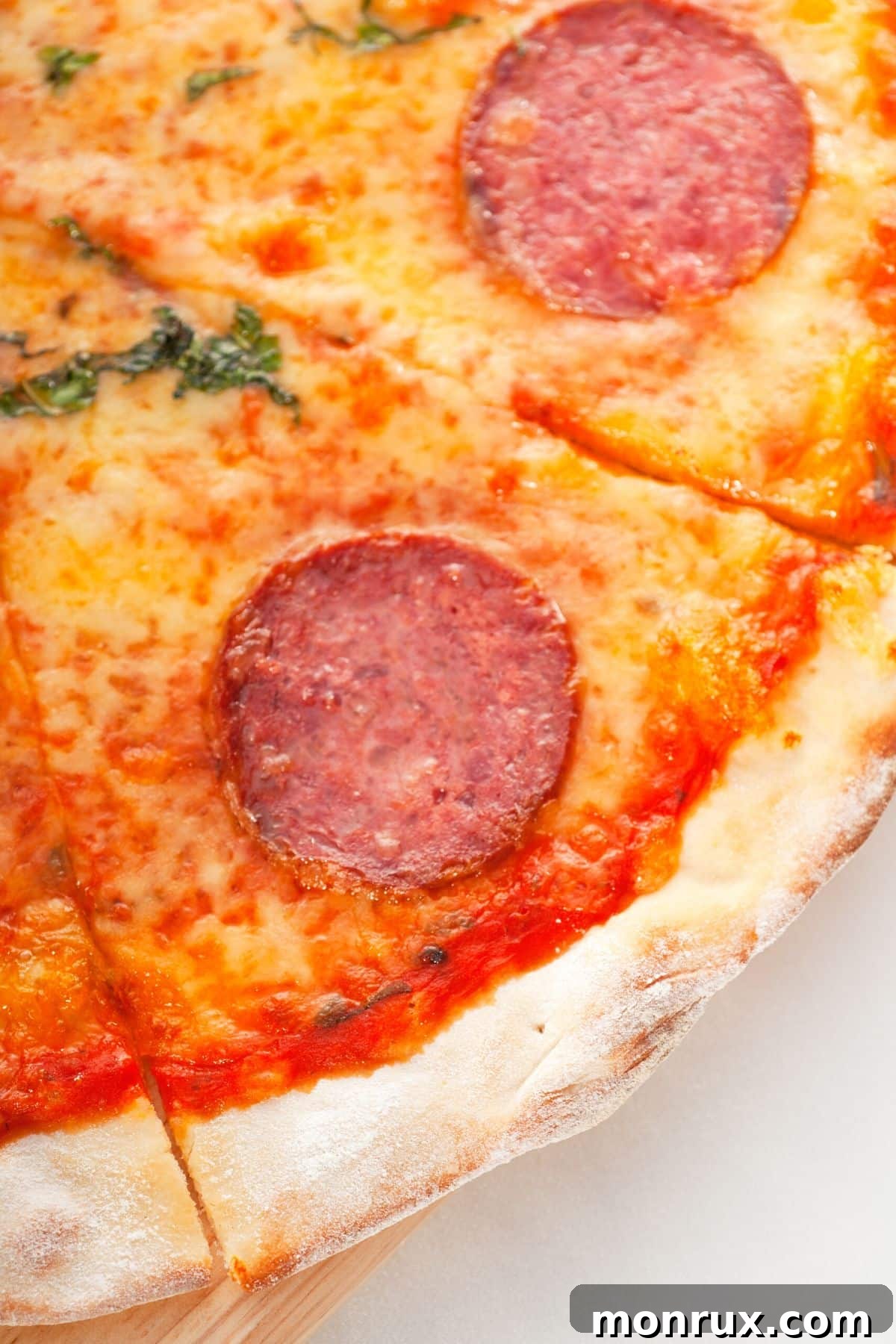 Close-up photo of a delicious slice of cassava crust pizza with vegan cheese and basil.