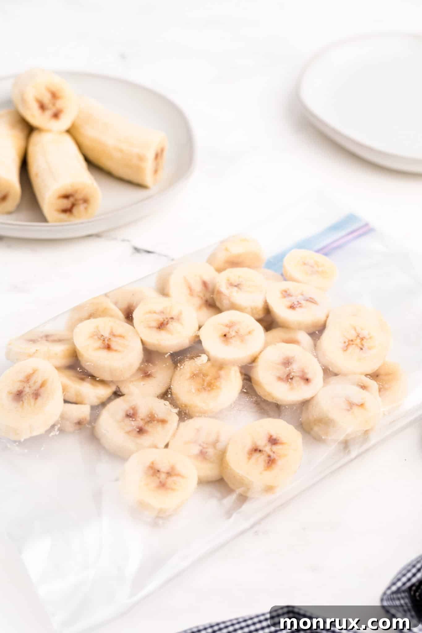 Frozen banana slices in a zipper top bag on a white counter.