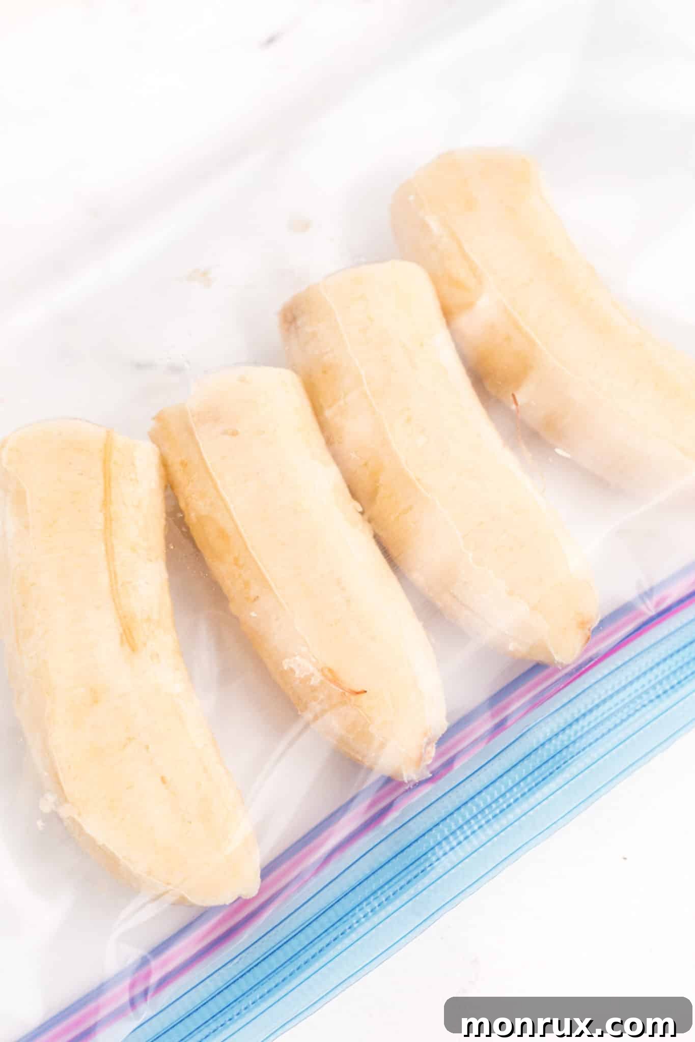 Four frozen banana halves in a zipper top bag.