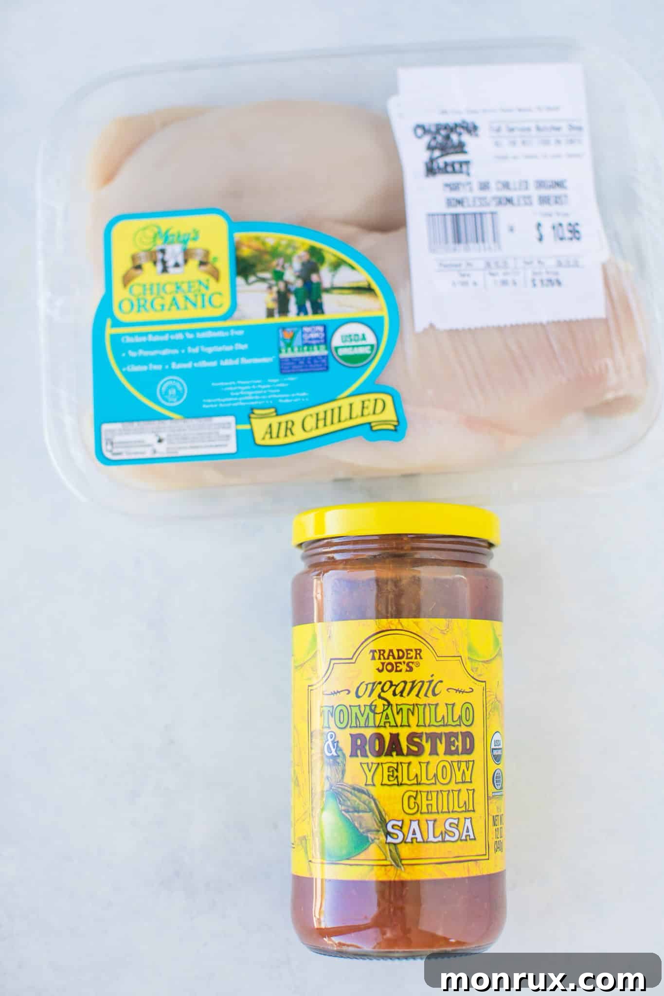 Simple ingredients for Instant Pot Salsa Chicken laid out: jarred salsa, chicken cutlets, and a measuring cup of water.