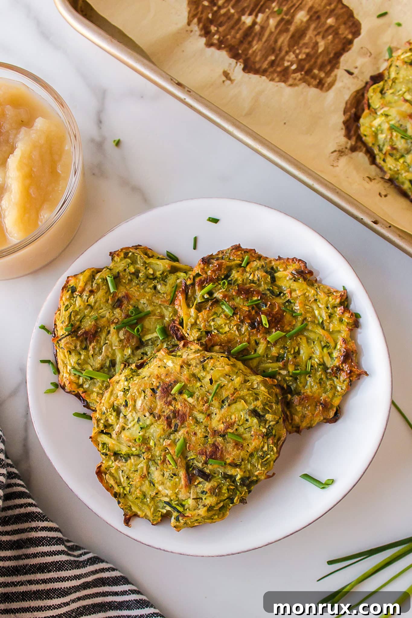 Plate with a tempting stack of golden-brown baked zucchini potato fritters, ready to be enjoyed.