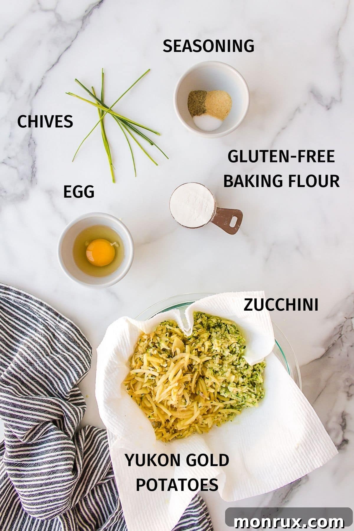 Fresh ingredients laid out for making zucchini fritters, including grated zucchini, potatoes, and an egg.