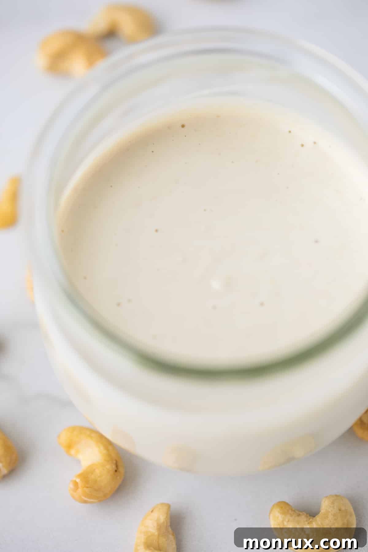 Smooth and creamy cashew cream sauce in a clear glass jar, ready for use.