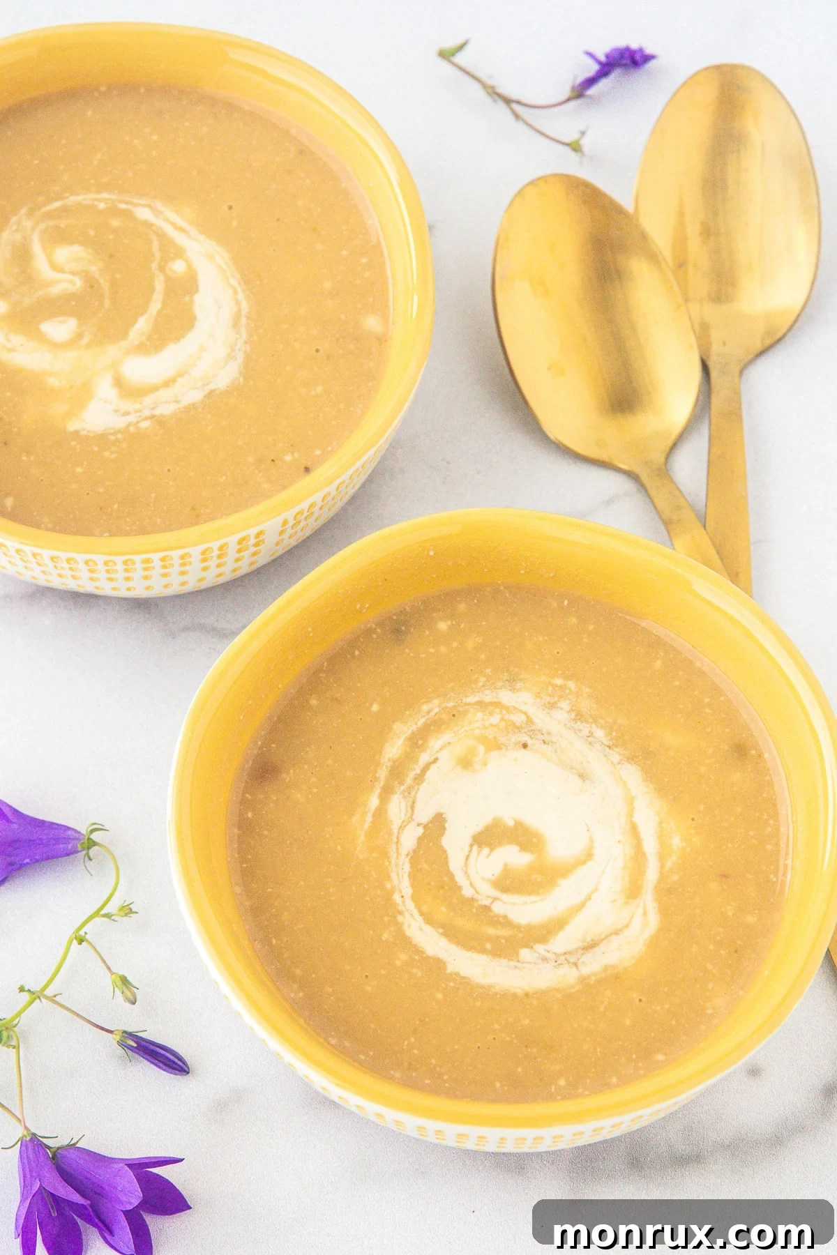 Delicious Zucchini Potato Soup topped with a swirl of homemade cashew cream sauce.