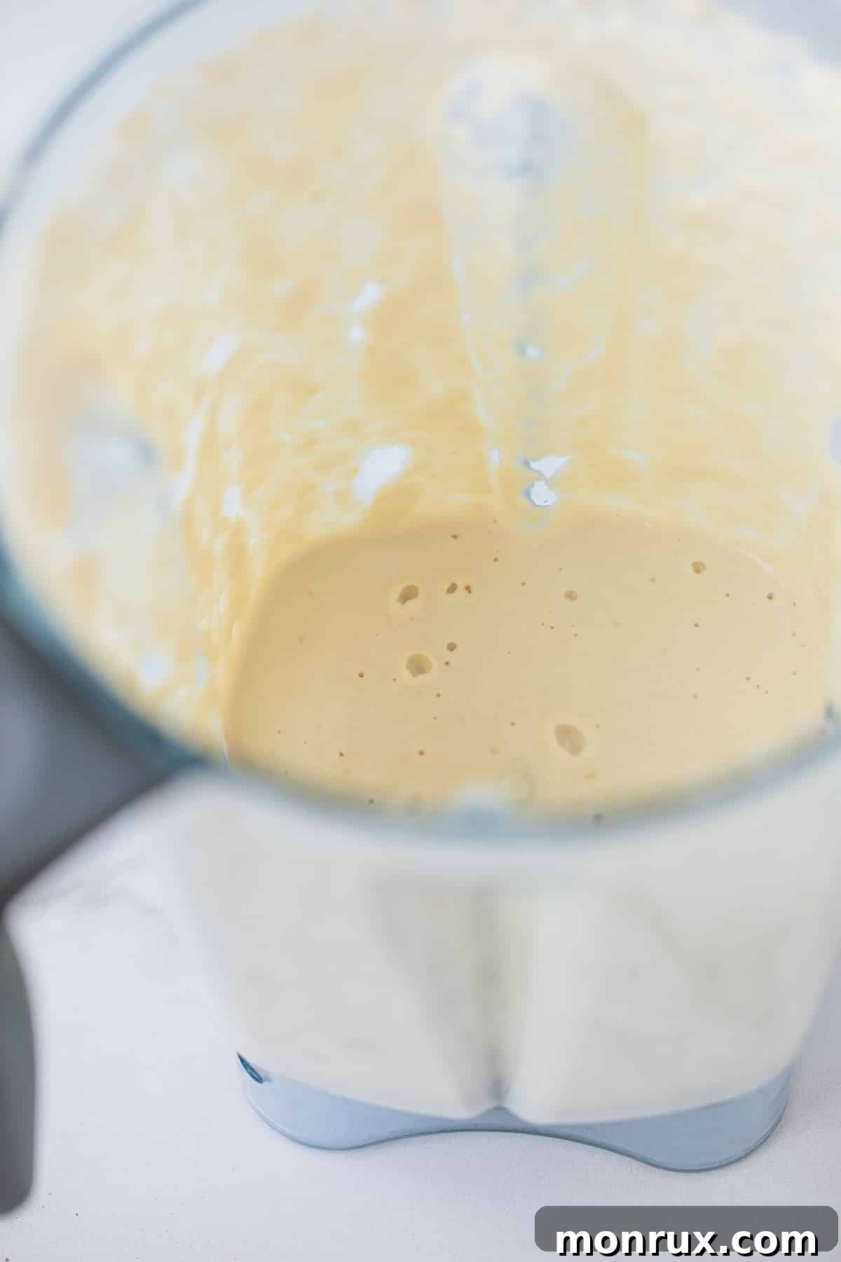 Creamy cashew sauce being blended in a high-speed blender.
