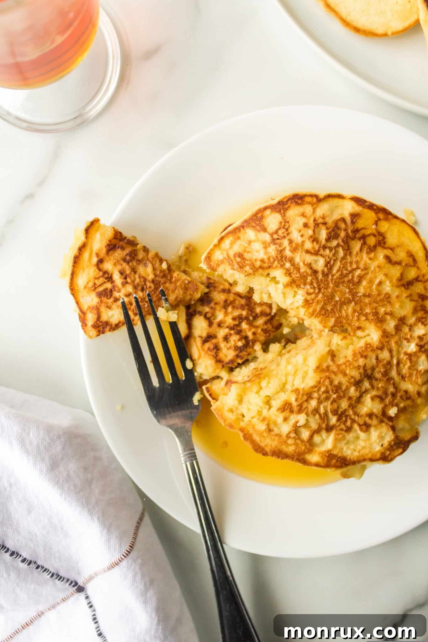A stack of fluffy rice flour pancakes on a plate, adorned with fresh berries and a fork, ready to be enjoyed for a delicious breakfast.